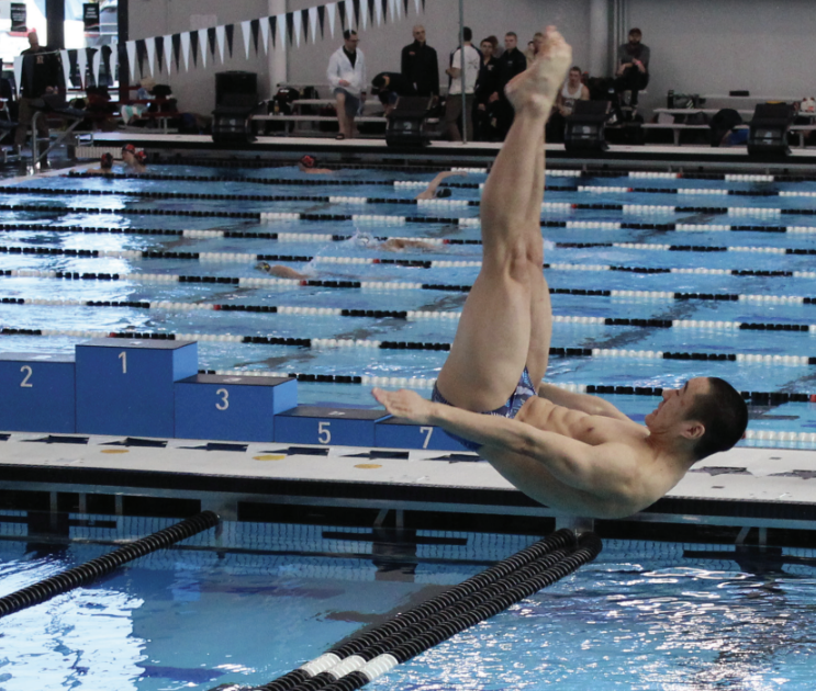 Senior Matthew Yuan performs a front two and a half pike during the IHSA State Diving Championship on Feb. 28. Despite starting in last place after completing two dives, he finished first with 566.25 points. 